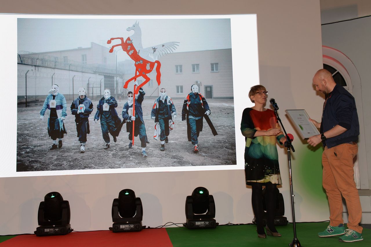 Michał Szlaga odbiera nagrodę za zajęcie III miejsca w kat. Kultura i sztuka za zdjęcie wykonane w Zakładzie Karnym w Iławie. Jest to dokumentacja akcji artystycznej Jerzego Bohdana Szumczyka „Lisowczycy”, która jest jedną z akcji warsztatów artystycznych prowadzonych w wybranych więzieniach w Polsce przez najciekawszych polskich artystów młodego i średniego pokolenia.