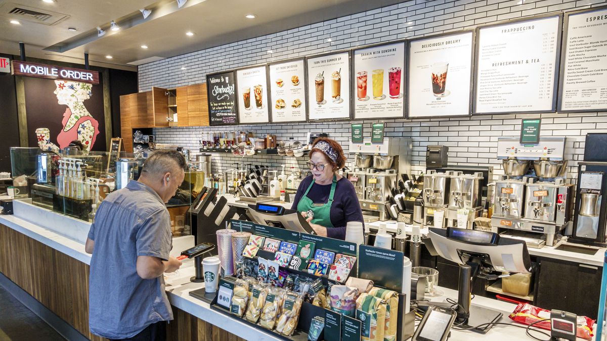 Charlotte, North Carolina, Starbucks Coffee, barista taking order, credit card scanner. (Photo by: Jeffrey Greenberg/Universal Images Group via Getty Images)