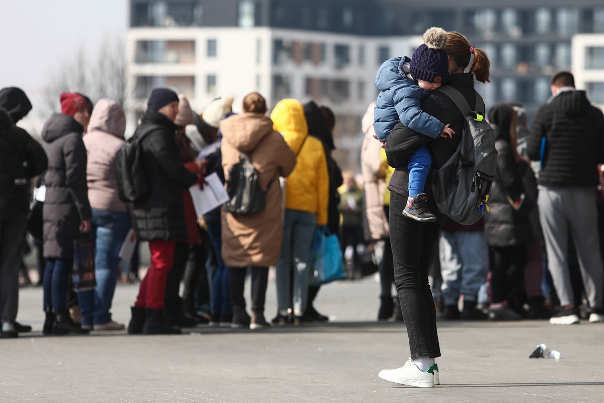 People fleeing from Ukraine wait in a line outside Tauron Arena sports hall where registration point for National Identification Number is opened, in Krakow, Poland on March 16, 2022. Tens of thousends Ukrainian refugees come to Poland due Russian invasion and from March 16 they can register in the Polish national PESEL identification number system. (Photo by Jakub Porzycki/NurPhoto via Getty Images)