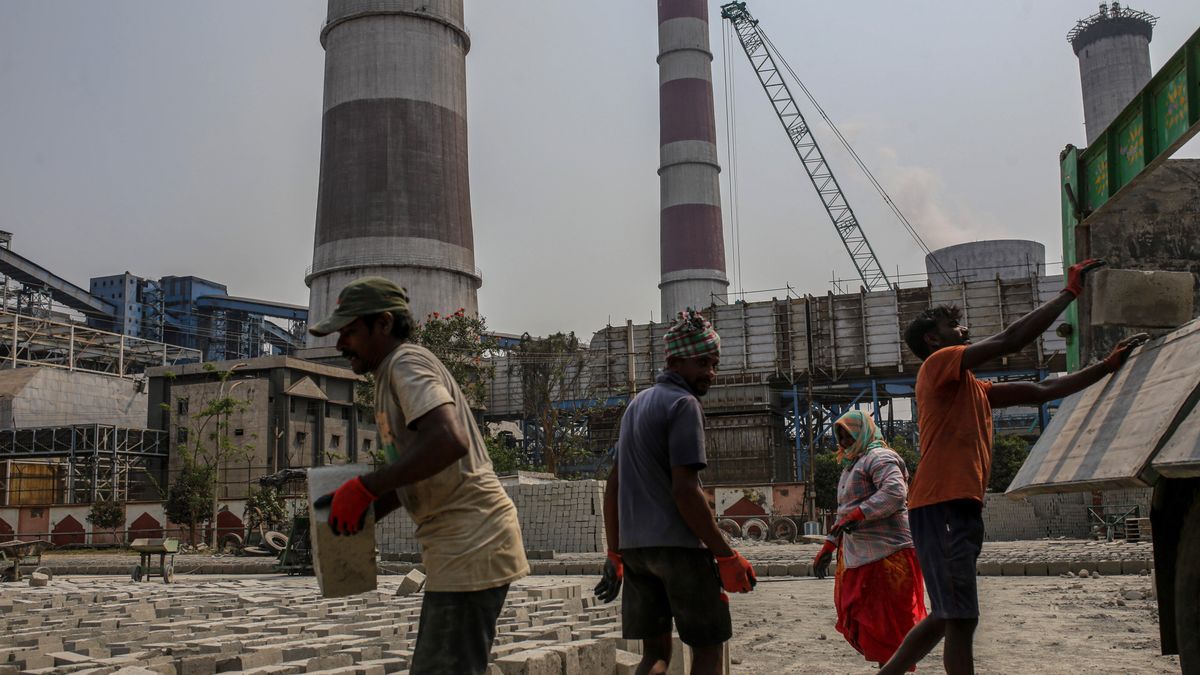 Workers at a concrete block manufacturing factory near the coal-fired NTPC Simhadri thermal power plant in the outskirts of Visakhapatnam, Andhra Pradesh, India, on Sunday, March 20, 2022. India, the worlds third biggest emitter of greenhouse gases, plans to more than triple its clean-energy capacity by the end of the decade and zero out emissions by 2070. Photographer: Dhiraj Singh/Bloomberg via Getty Images