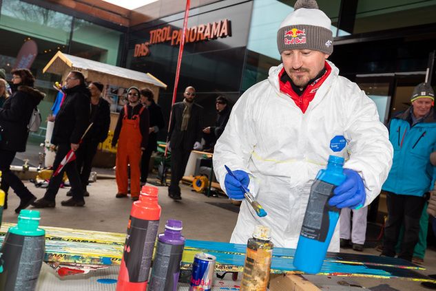 Adam Małysz nakłada farty na spody nart przed stworzeniem obrazu (fot. Tommy Bause)