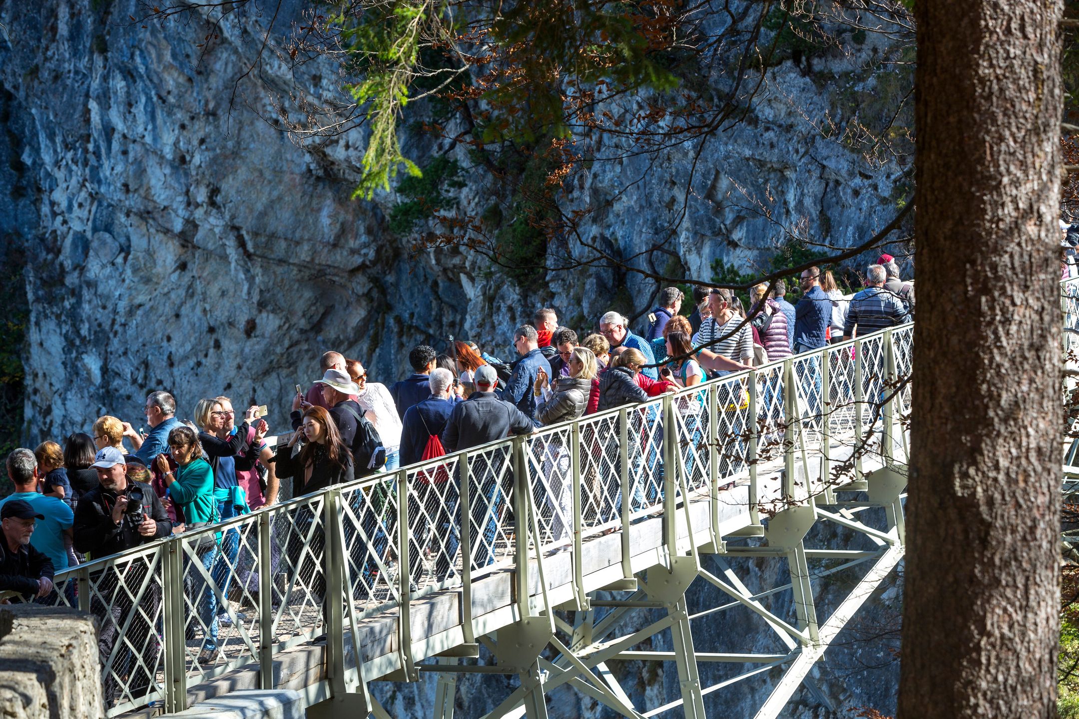 Turyści na moście prowadzącym do zamku Neuschwanstein