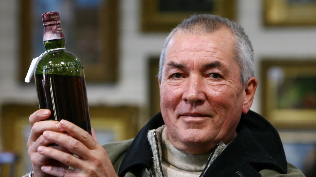 Bob Pert trzyma butelkę szkockiej, którą uratowano ze statku SS Politician / Gareth Fuller - PA Images