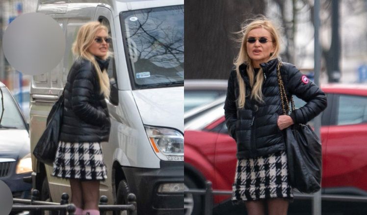 Zmarznięta Monika Olejnik w krótkiej spódniczce i różowych podkolanówkach wyczekuje na chodniku z walizką (ZDJĘCIA)