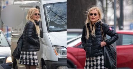 Zmarznięta Monika Olejnik w krótkiej spódniczce i różowych podkolanówkach wyczekuje na chodniku z walizką (ZDJĘCIA)