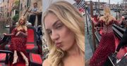 Caroline Derpienski w czerwonej sukni stroi miny na GONDOLI w Wenecji