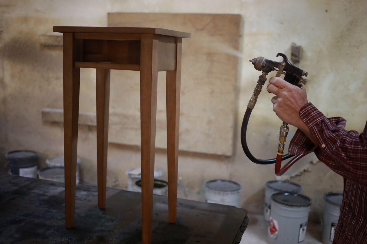 A factory worker applies a coat of stain to a piece of handmade wooden furniture at the Colonial House Furniture Inc. wood shop in Auburn, Kentucky, U.S., on Wednesday, Dec. 1, 2021. The U.S. Census Bureau is scheduled to release durable goods orders figures on December 3. Photographer: Luke Sharrett/Bloomberg via Getty Images