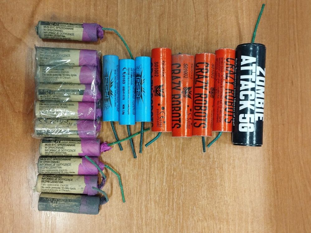 Zestaw różnokolorowych petard ułożony na drewnianym blacie.