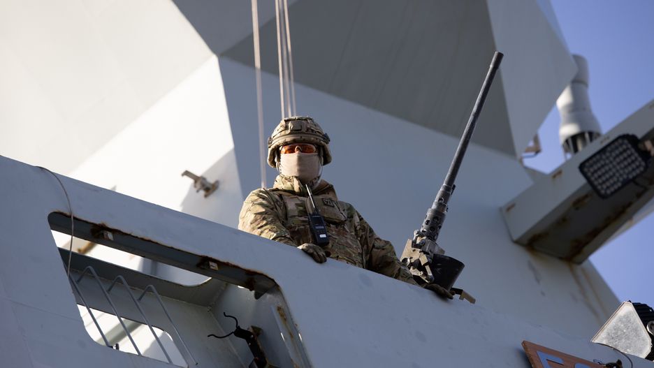 An armed soldier watches from the deck of the Danish Absalon-class frigate Esbern Snare (F342), part of the Standing NATO Maritime Group, moored at the passenger port in Riga, Latvia, on Sunday, Oct. 30, 2022. For the Baltics, Moscow will remain a threat in eastern Europe regardless of the outcome of the war, with no indication that Kremlins foreign policy will change, Mikk Marran, Estonias outgoing espionage chief, said. Photographer: Andrey Rudakov/Bloomberg via Getty Images