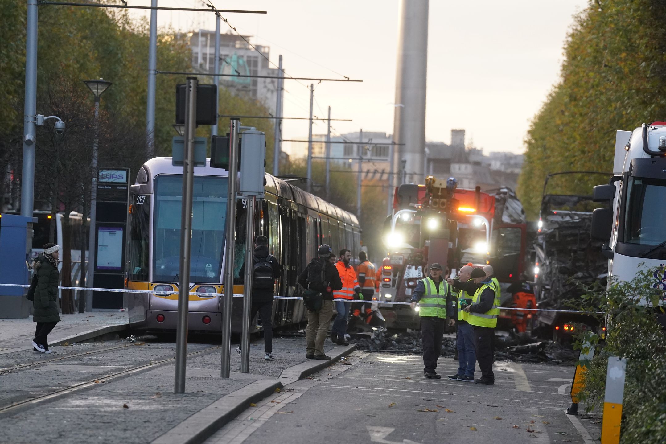 Debris is cleared from a burned out Luas and bus on O'Connell Street in Dublin, in the aftermath of violent scenes in the city centre on Thursday evening. The unrest came after an attack on Parnell Square East where five people were injured, including three young children. Picture date: Friday November 24, 2023. (Photo by Brian Lawless/PA Images via Getty Images)