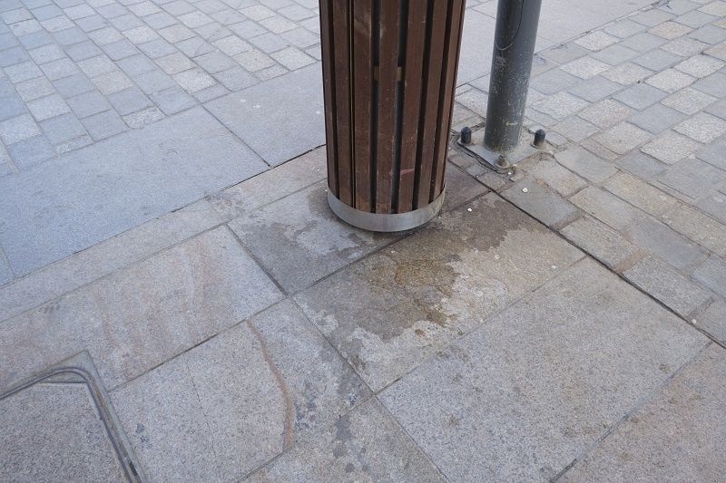 Plamy przy koszu na deptaku