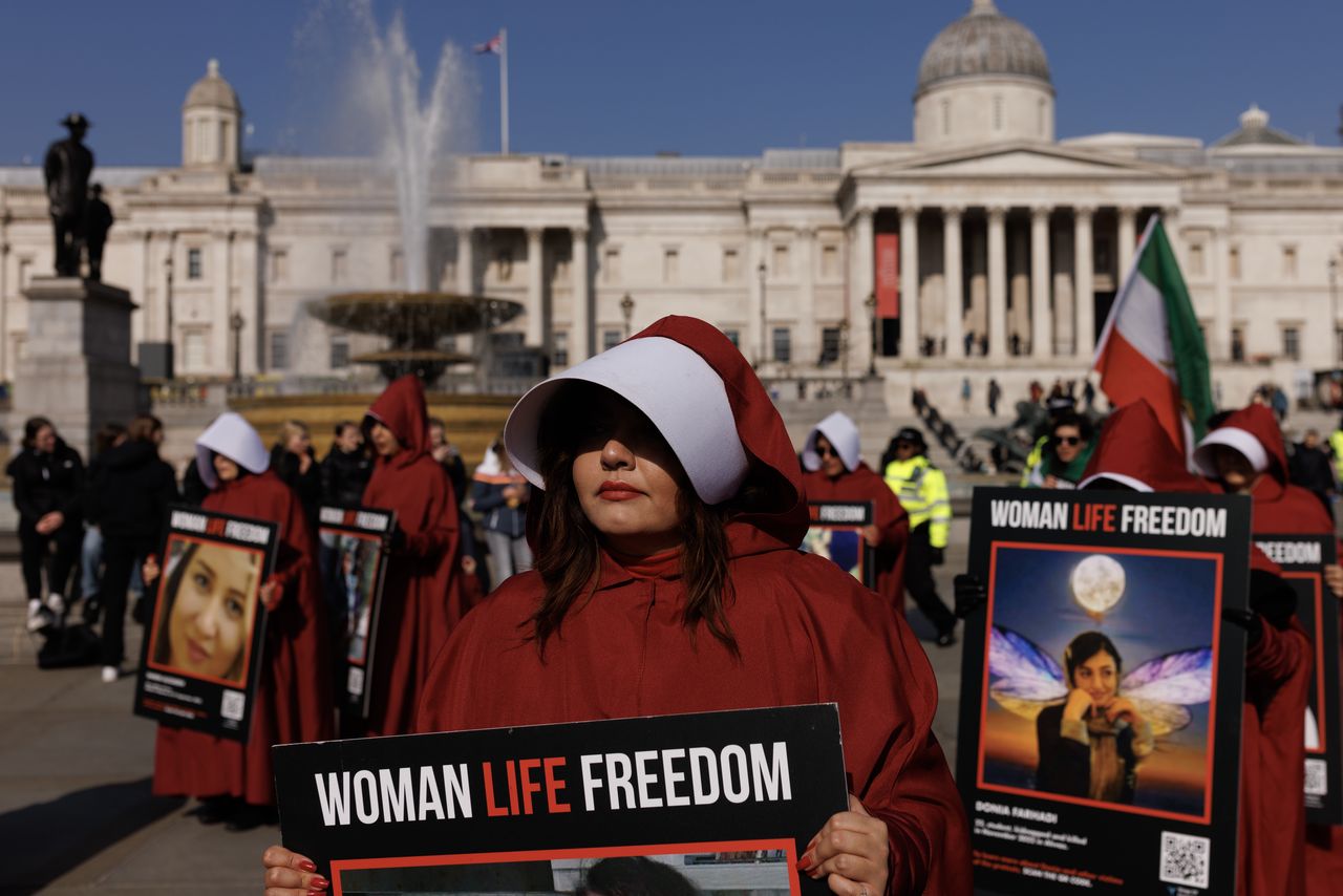 LONDON, ENGLAND - MARCH 8: Protesters dressed as handmaids from The Handmaid's Tale hold signs reading "Woman Life Freedom" during a march from Parliament Square to Iran's embassy to highlight repression of women in that country on March 8, 2024 in London, England. On March 8th International Women's Day celebrates the social, economic, cultural and political achievements of women globally and highlights the work still to be done to prevent endemic violence against women and inequality. (Photo by Dan Kitwood/Getty Images)