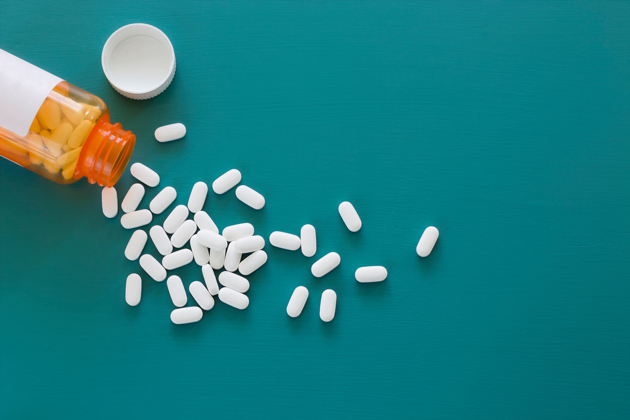 White pills scattered from an orange prescription bottle on a teal background.
SawBear\Kenn Navarro
pill, white, teal, blue, prescription, medicine, medication, medical, illness, pharmacy, treatment, plastic, health, tablet, background, bottle, care, nobody, jar, open, pain, overhead, copyspace, copy, dose, drugs, empty, healthcare, painkillers, table, supplements, top, view, vitamins, pharmaceuticals, space, concept, blank, painkiller, detail, dosage, drug, healthy, pharmaceutical, addiction, aspirin, cure, vitamin, antibiotics, chemistry