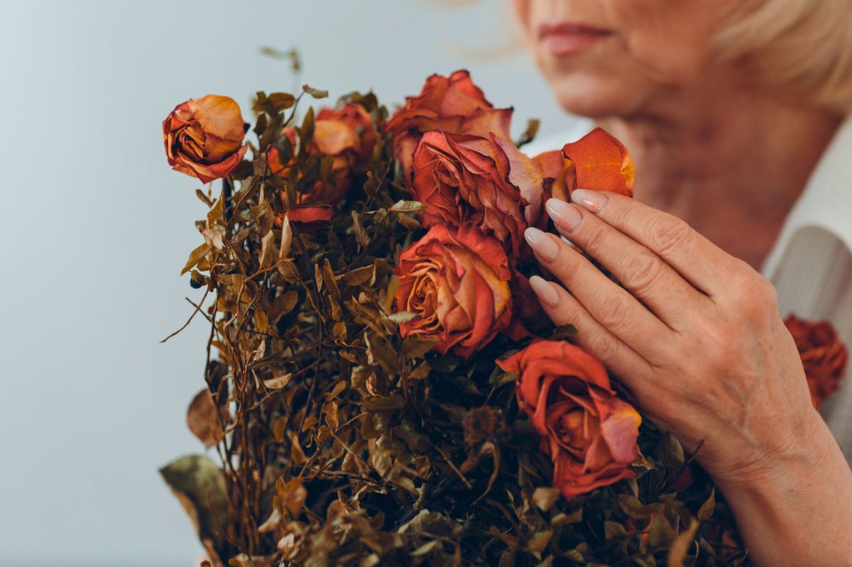 Kobieta trzyma bukiet suszonych róż