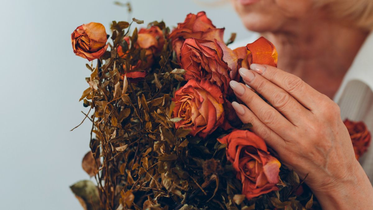 Kobieta trzyma bukiet suszonych róż