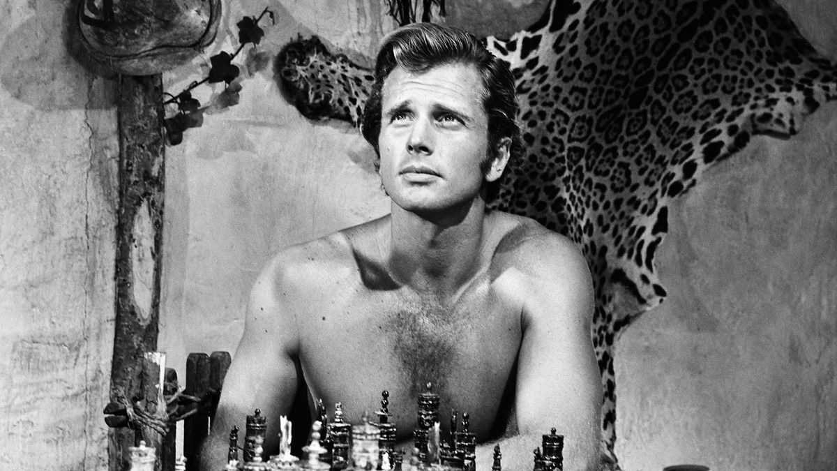 Tarzan - Season 1TARZAN -- "Basil of the Bulge" Episode 22 -- Pictured: (l-r) Ron Ely as Tarzan -- (Photo by: NBCU Photo Bank/NBCUniversal via Getty Images via Getty Images)NBC1960s, 1966-1967, Air Date 02/10/1967, B&W, Black & White, NBCU Photo Bank, NUP_147863, bare chest, chess, drama, episodic, game, indoor, leopard skin, season 1, select, shiurtless, single, solo