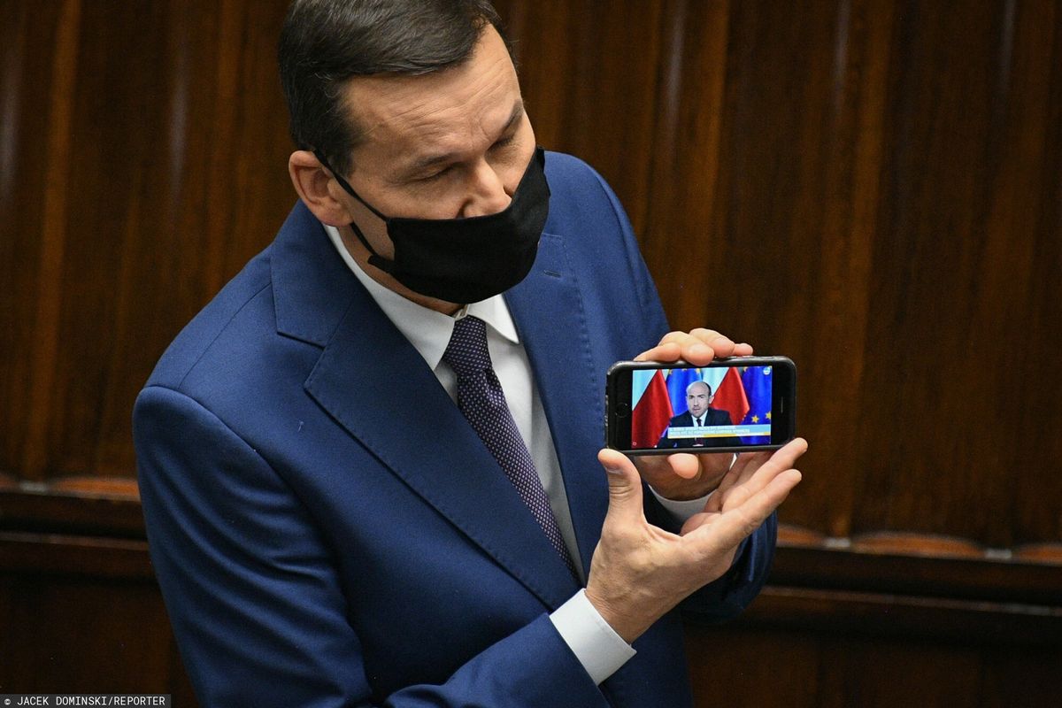 Premier Mateusz Morawiecki (na ekranie telefonu Borys Budka)