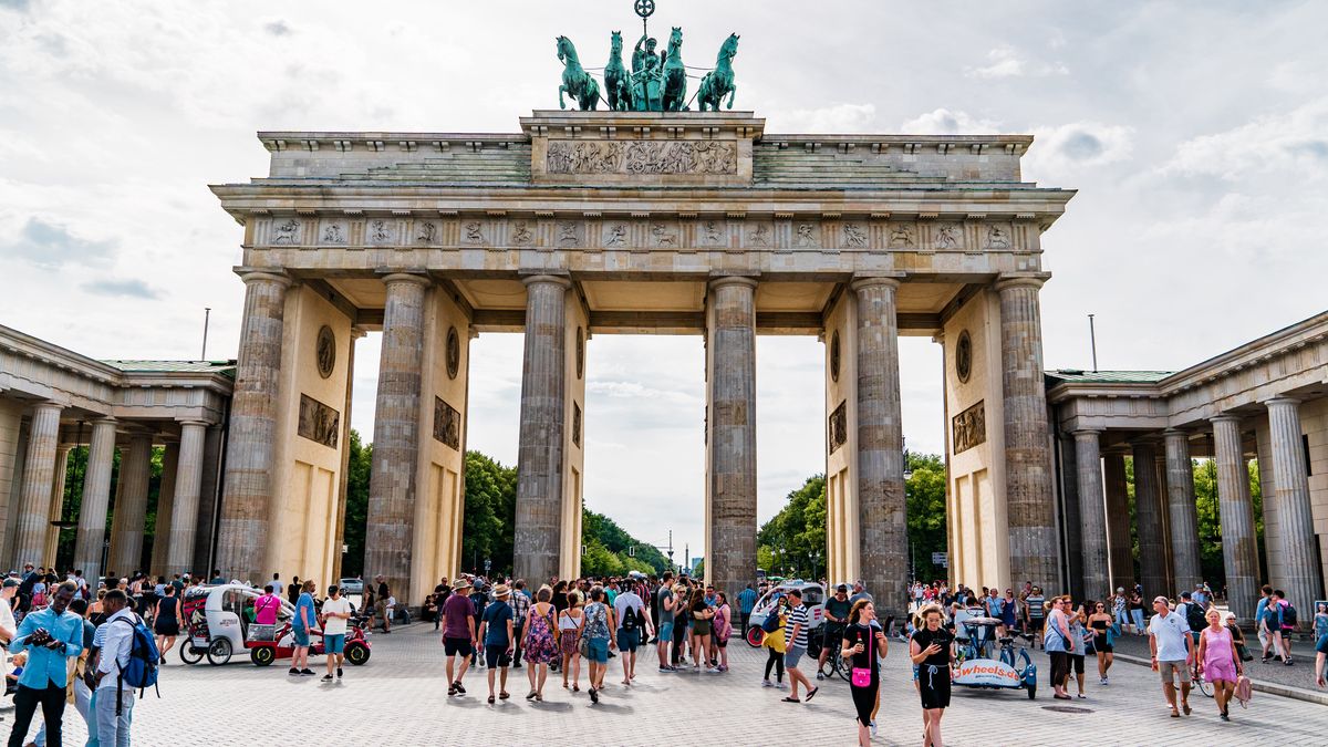 Summer day in Berlin - people walking near the  Brandenburger Tor. Constructed between 1788 and 1791, the Brandenburg Gate was Berlin’s first Greek revival building. Designed by Carl Gotthard Langhans, architect to the Prussian court, it was inspired by the monumental gateway at the entrance to the Acropolis in Athens.