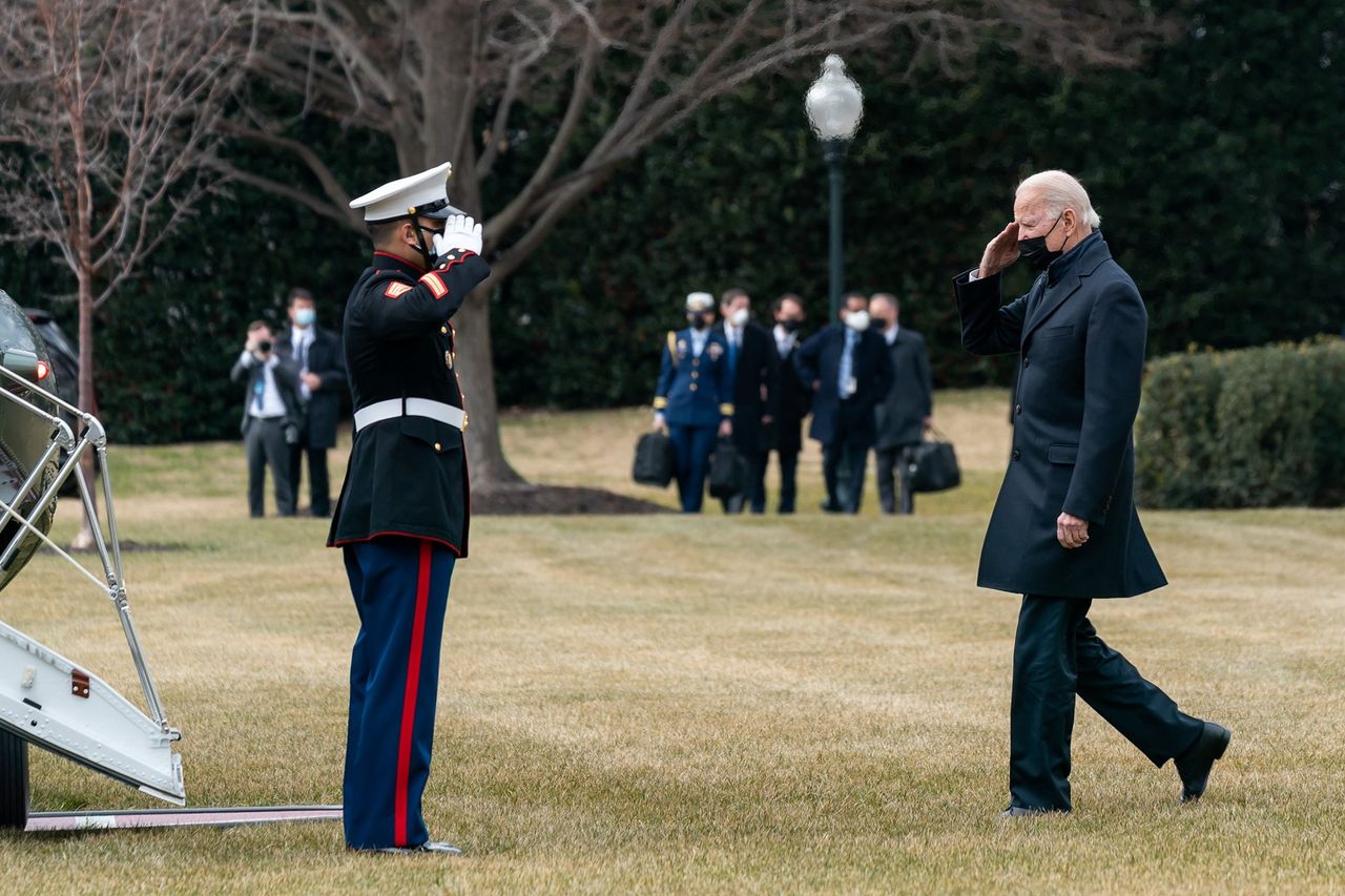 One of the officers visible in the background is carrying a "football".