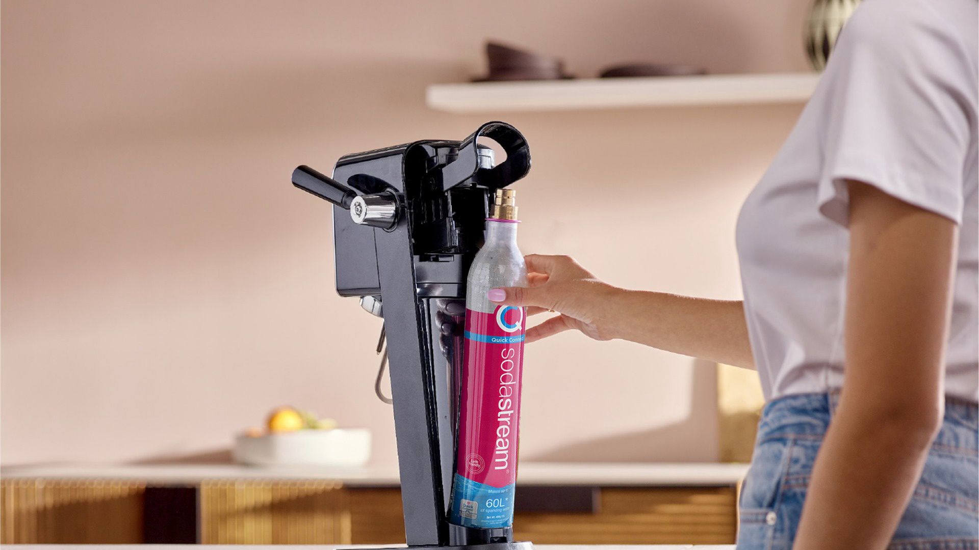  Kobieta wymienia cylinder CO2 w saturatorze SodaStream Art z technologią Quick Connect. 