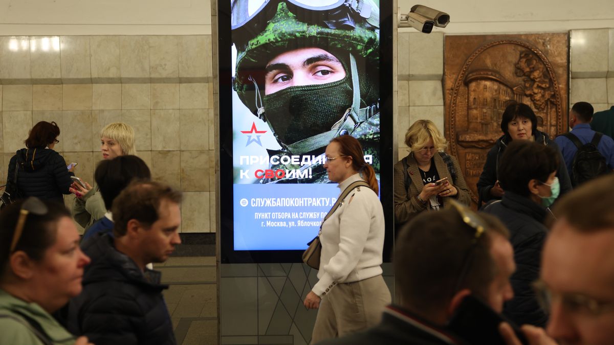 MOSCOW, RUSSIA - MAY 12: (RUSSIA OUT) Passengers walk past a billboard, advertising contract service in the army, at the subway station, on May 12, 2023 in Moscow, Russia. The sign reads: 'The real job". The Russian Ministry of Defense plans to recruit 400,000 contract soldiers this spring for the war in Ukraine. (Photo by Contributor/Getty Images)