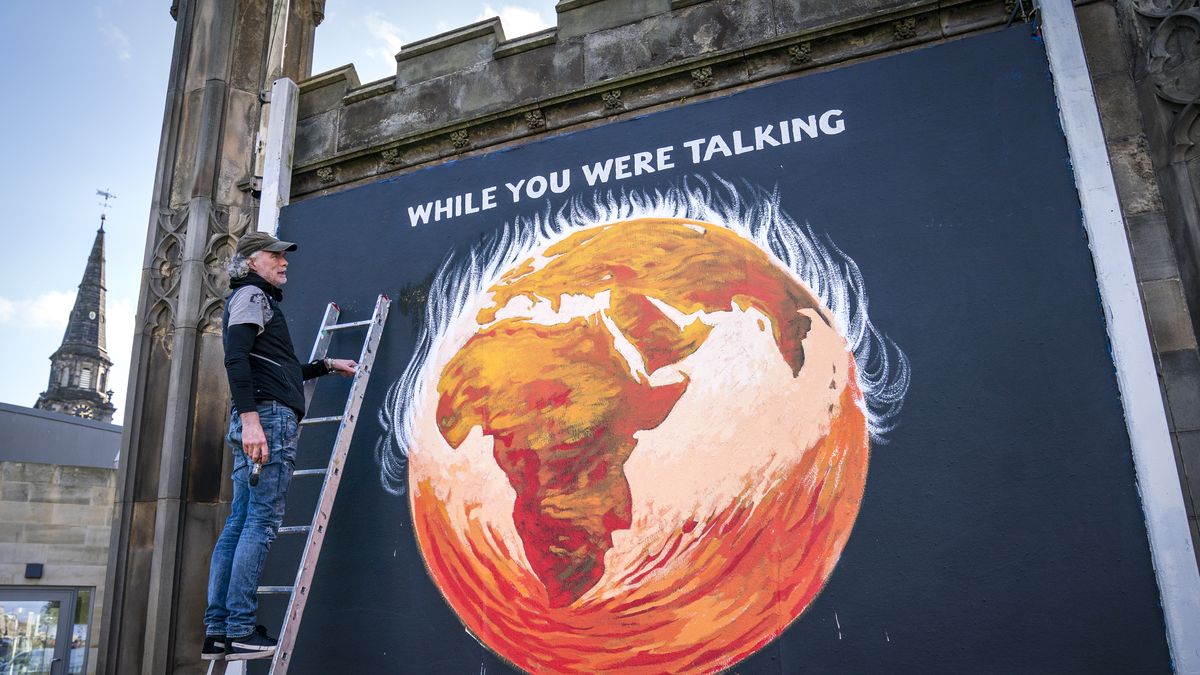 Justice and Peace artist Greg Mitchell completes his climate-crisis themed mural that depicts the Earth on fire and reads ' While you were talking', on the side of St John's Church on Princes Street, Edinburgh, to coincide with the Cop26 in Glasgow. Picture date: Monday October 25, 2021. (Photo by Jane Barlow/PA Images via Getty Images)