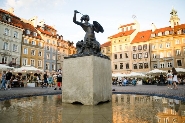 WARSAW, POLAND - 2022/06/25: The monument of the Mermaid of Warsaw, the symbol of the Polish capital, is seen in the centre of Warsaw's Old Town. Daily life summer evening in Warsaw Old town after a hot Saturday. (Photo by Volha Shukaila/SOPA Images/LightRocket via Getty Images)