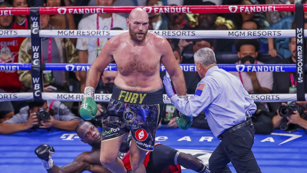 epa09516046 Tyson Fury of England (C) reacts after knocking down Deontay Wilder (L) of the USA during their 12 round WBC heavyweight world championship title fight at the T-Mobile Arena in Las Vegas, Nevada, USA, 09 October 2021.  EPA/ETIENNE LAURENT Dostawca: PAP/EPA.