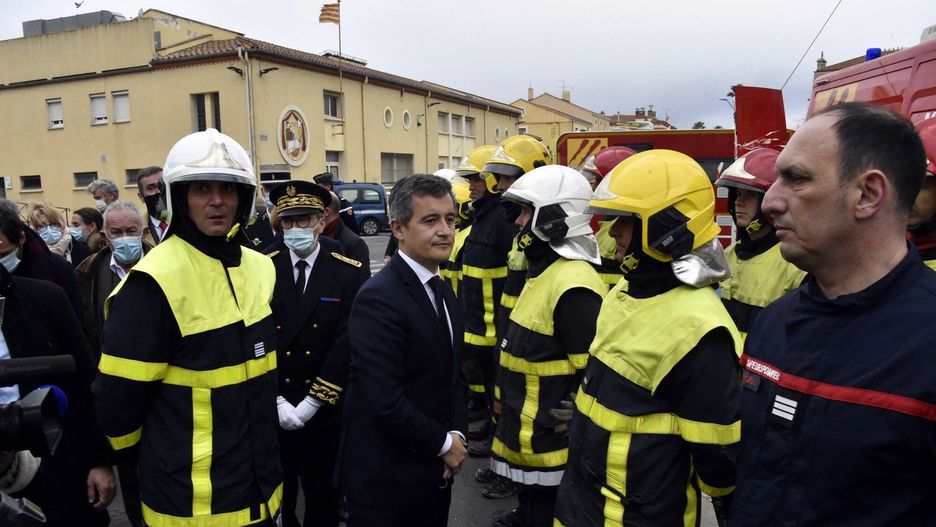 TemporaryGerald France's Interior Minister Gerald Darmanin (C) speaks with  firefighters as he arrives at the site of a fire that broke out in a habitation building, killing seven of its residents in Saint-Laurent-de-la- Salanque, on February 14, 2022. (Photo by RAYMOND ROIG / AFP)RAYMOND ROIG