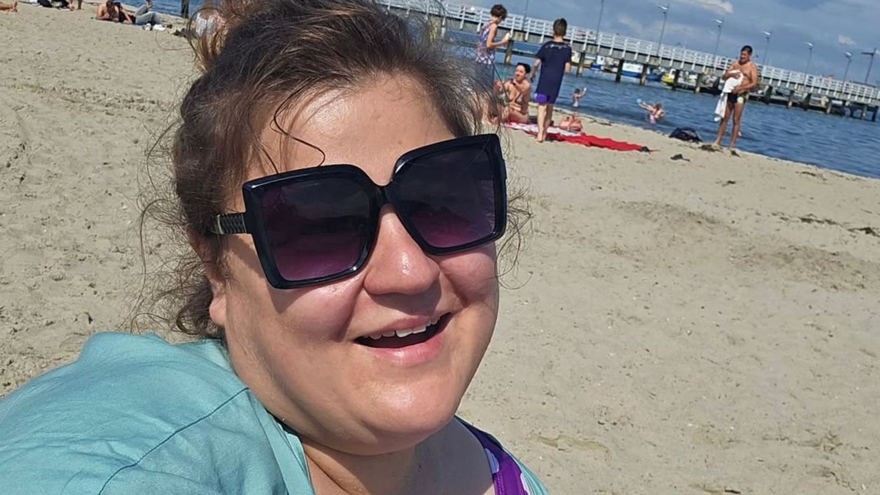 Dominika Gwit wypoczywa na plaży. Ciemne okulary, kapelusz i kostium w grochy