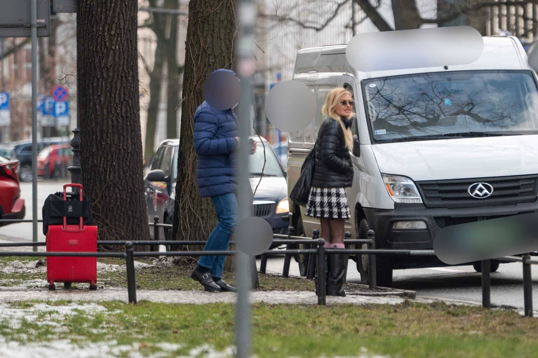 Monika Olejnik w krótkiej spódnicy czeka przy ulicy z walizkami