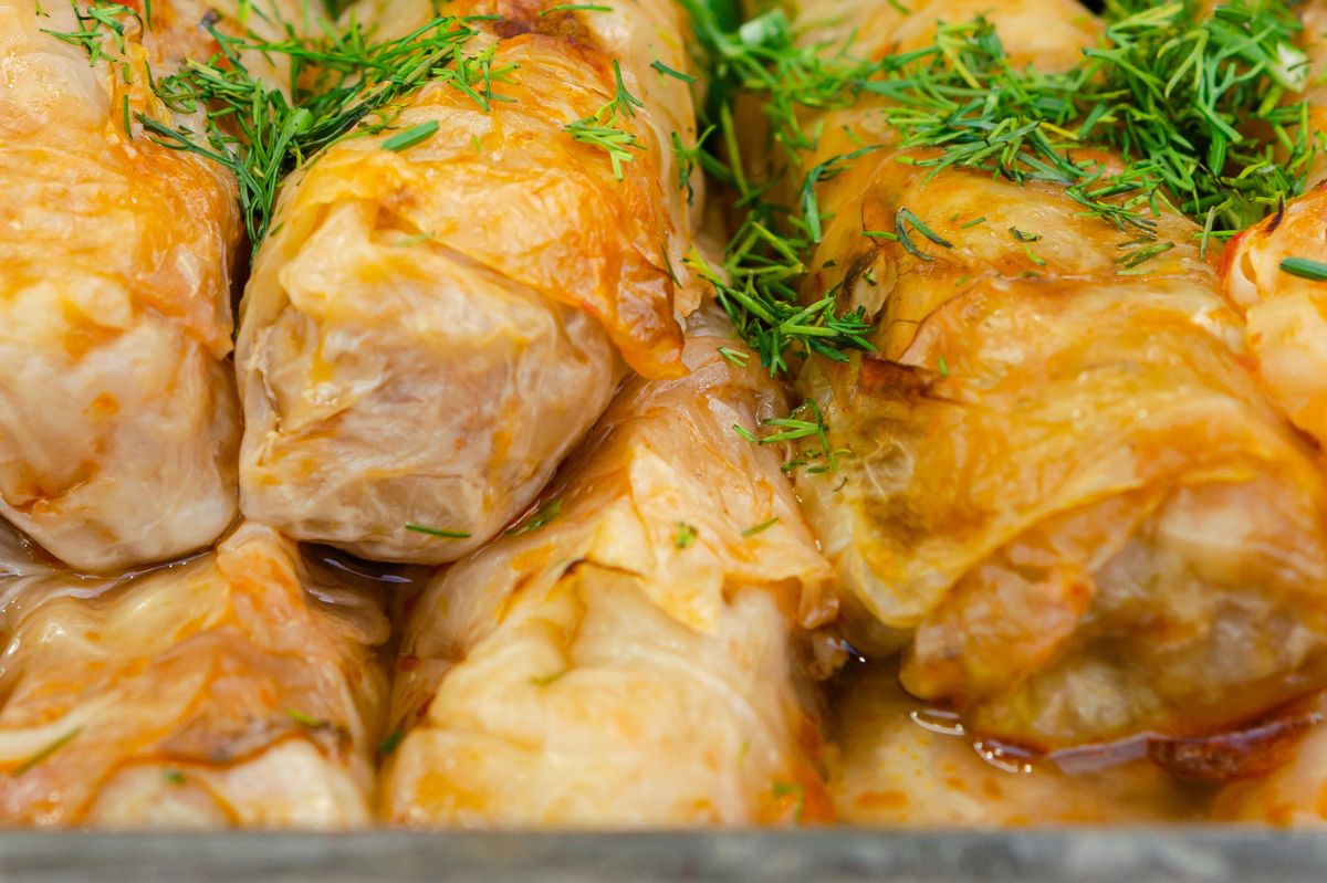 Stuffed cabbage rolls made with sauerkraut are tender and flavorful.