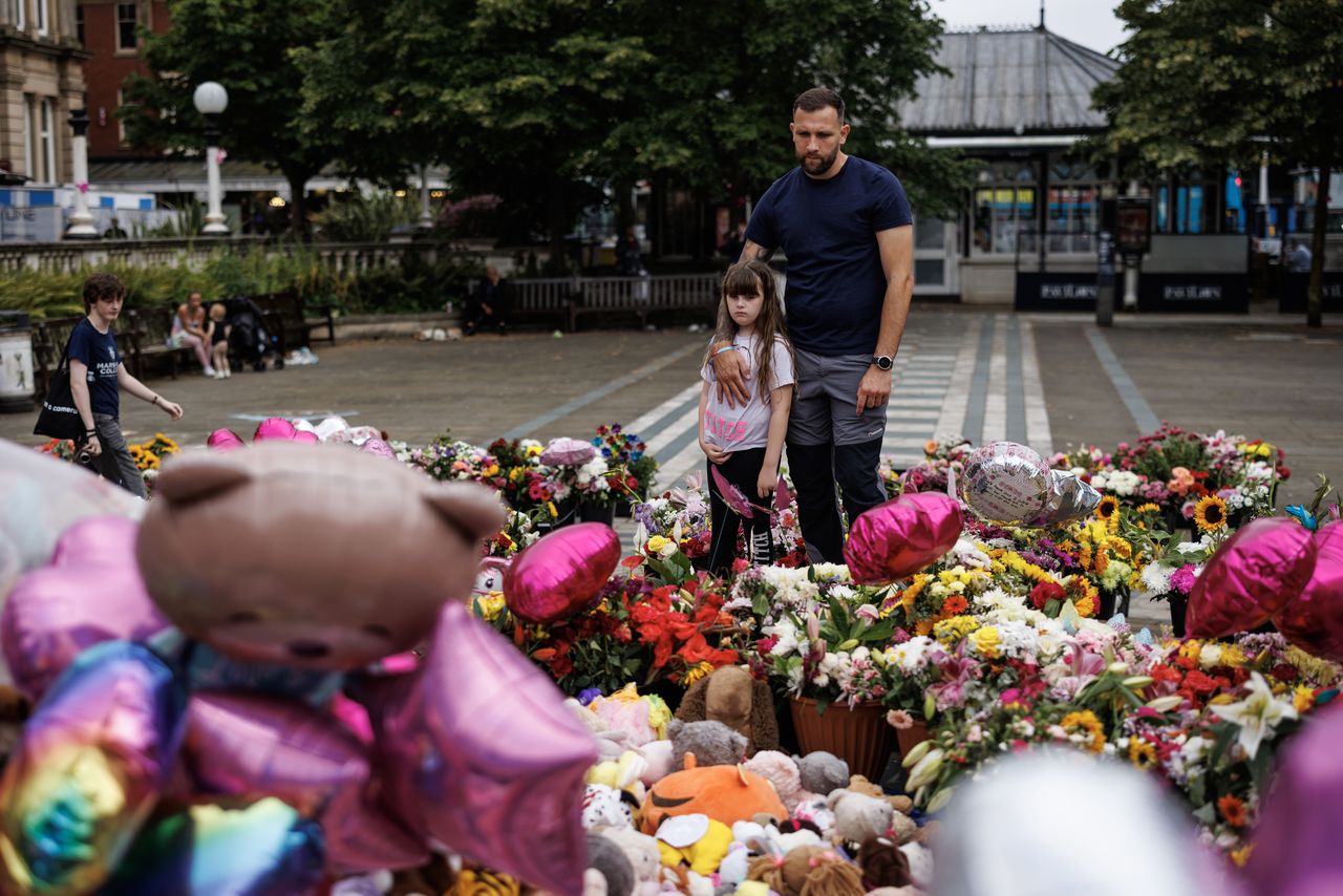 SOUTHPORT, ENGLAND - AUGUST 05: Members of the community arrive ahead of a vigil to remember the victims of last week's knife attack near the Atkinson on August 5, 2024 in Southport, England. One week ago, three young girls, Bebe King, 6, Elsie Dot Stancombe, 7, and Alice Dasilva Aguiar, 9, were killed, and several other people were seriously injured, when 17-year-old Axel Muganwa Rudakubana went on a stabbing spree in a Taylor Swift-themed dance class in Southport. The incident, as well as false information that the suspect was an immigrant, sparked a wave of anti-immigrant protests and riots across the UK. (Photo by Dan Kitwood/Getty Images)