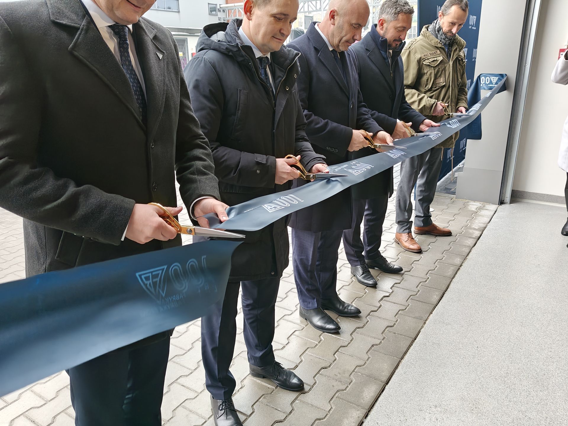 Uroczyste przecięcie wstęgi symbolizujące otwarcie nowej hali.