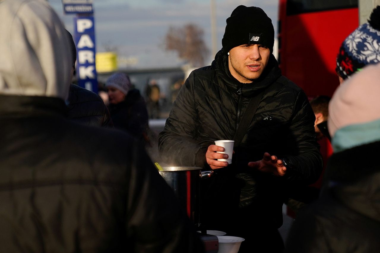 Mężczyzna proponuje kawę osobom, które dopiero co przekroczyły granicę w Medyce.