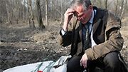 Mężczyzna opłakuje Ofiary katastrofy przy szczątkach samolotu
