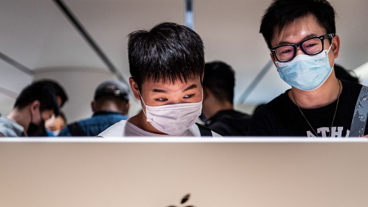 WUHAN, CHINA - 2022/05/21: Chinese customers wearing masks try an iMac at the official opening of the new Apple Store in Wuhan International Plaza, Wuhan. Apple opened its first flagship store in Wuhan, also the 54th flagship store in Greater China. (Photo by Ren Yong/SOPA Images/LightRocket via Getty Images)