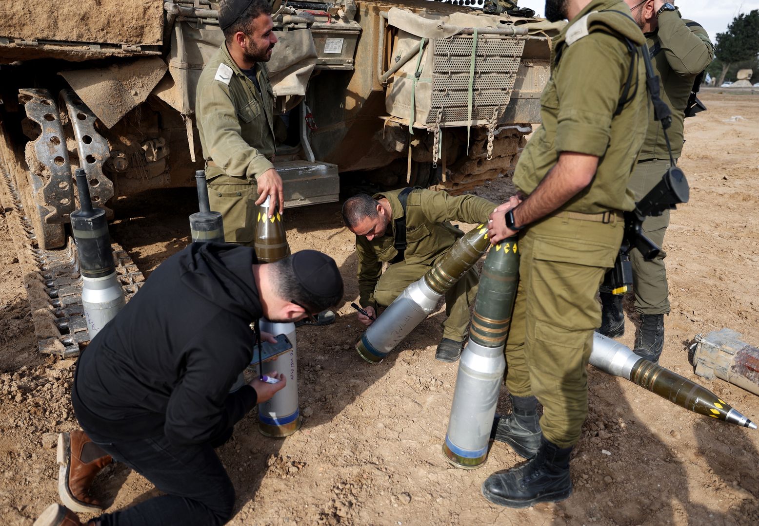 An Israeli soldier writes on tank shells Hebrew inscriptions at an army gathering along the border with Gaza, 21 November 2023. As part of Israel's 'ground operations' in the Gaza Strip, Israeli military aircraft struck approximately 250 Hamas targets over the last day, the IDF announced on 21 November. More than 12,000 Palestinians and at least 1,200 Israelis have been killed, according to the Israel Defense Forces (IDF) and the Palestinian health authority, since Hamas militants launched an attack against Israel from the Gaza Strip on 07 October, and the Israeli operations in Gaza and the West Bank which followed it. EPA/ATEF SAFADI Dostawca: PAP/EPA.