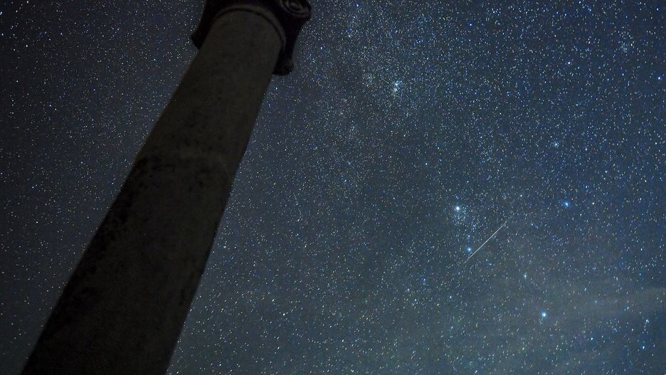 epa09410569 The meteors streak through the sky during the Perseid meteor shower over the archaeological site Stobi, near Negotino, Republic of North Macedonia, 12 August 2021. The Perseid meteor shower occurs every year in August when the Earth passes through debris and dust of the Swift-Tuttle comet.  EPA/GEORGI LICOVSKI Dostawca: PAP/EPA.