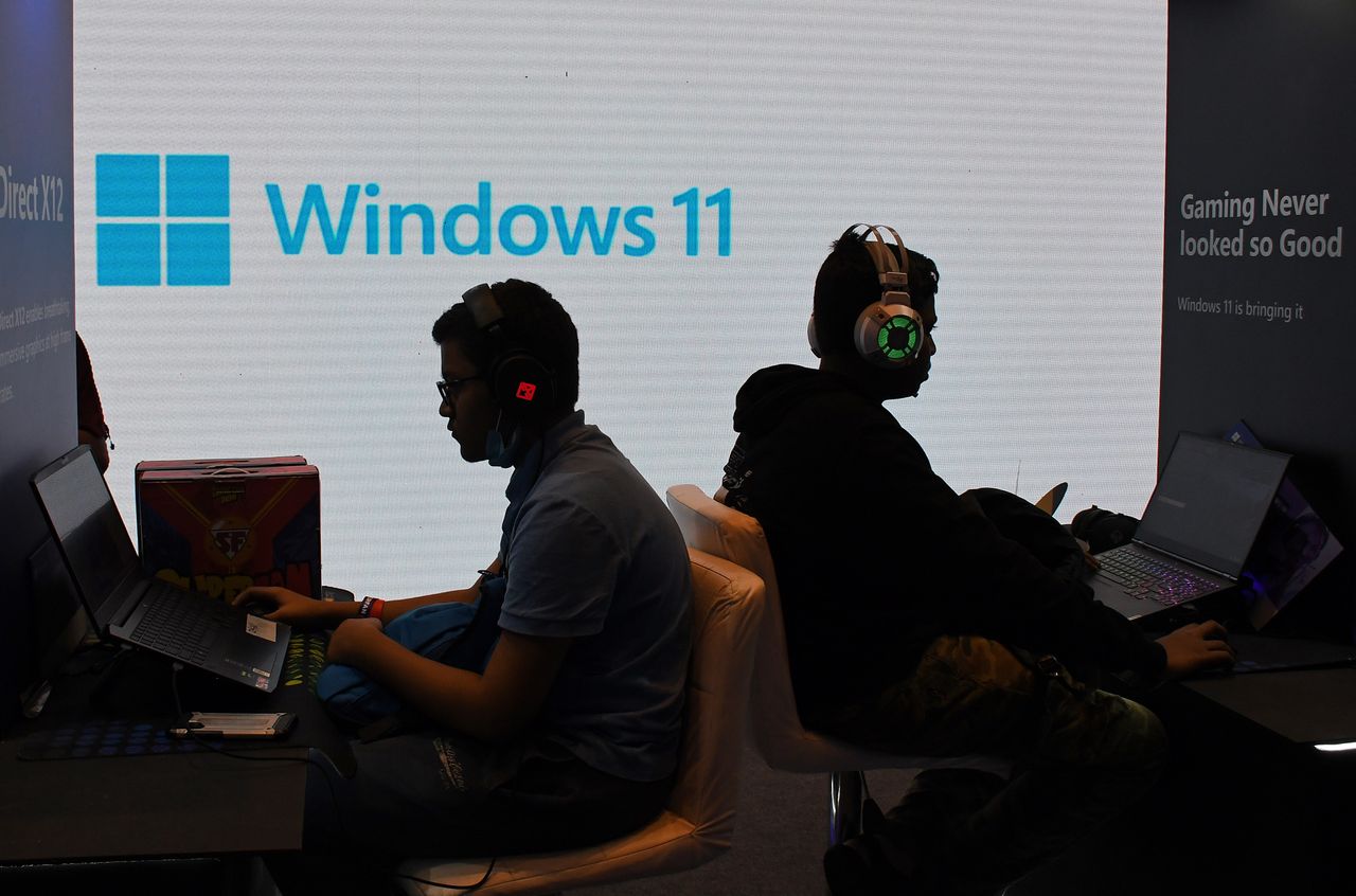 MUMBAI, INDIA - 2023/02/11: People seen playing videogames on laptops as Windows 11 logo flash on the screen at Comic Con event. The "Mumbai Comic Con 2023" event is held again after two years gap due to the coronavirus pandemic. (Photo by Ashish Vaishnav/SOPA Images/LightRocket via Getty Images)