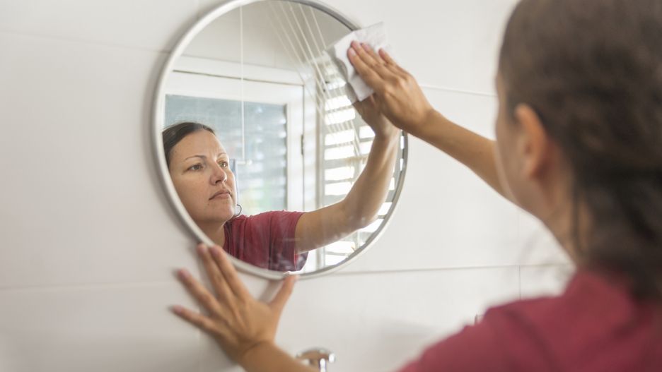 Maid cleaning round mirror with paper wipe
Woman cleaning a round mirror on the wall, wipping it with paper.
pabst_ell