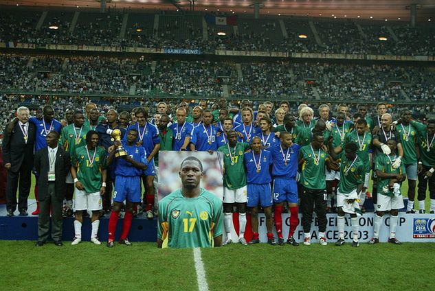 Na zdjęciu: piłkarze Kamerunu i Francji po finale wspólnie pozują z trofeum oraz zdjęciem Foe