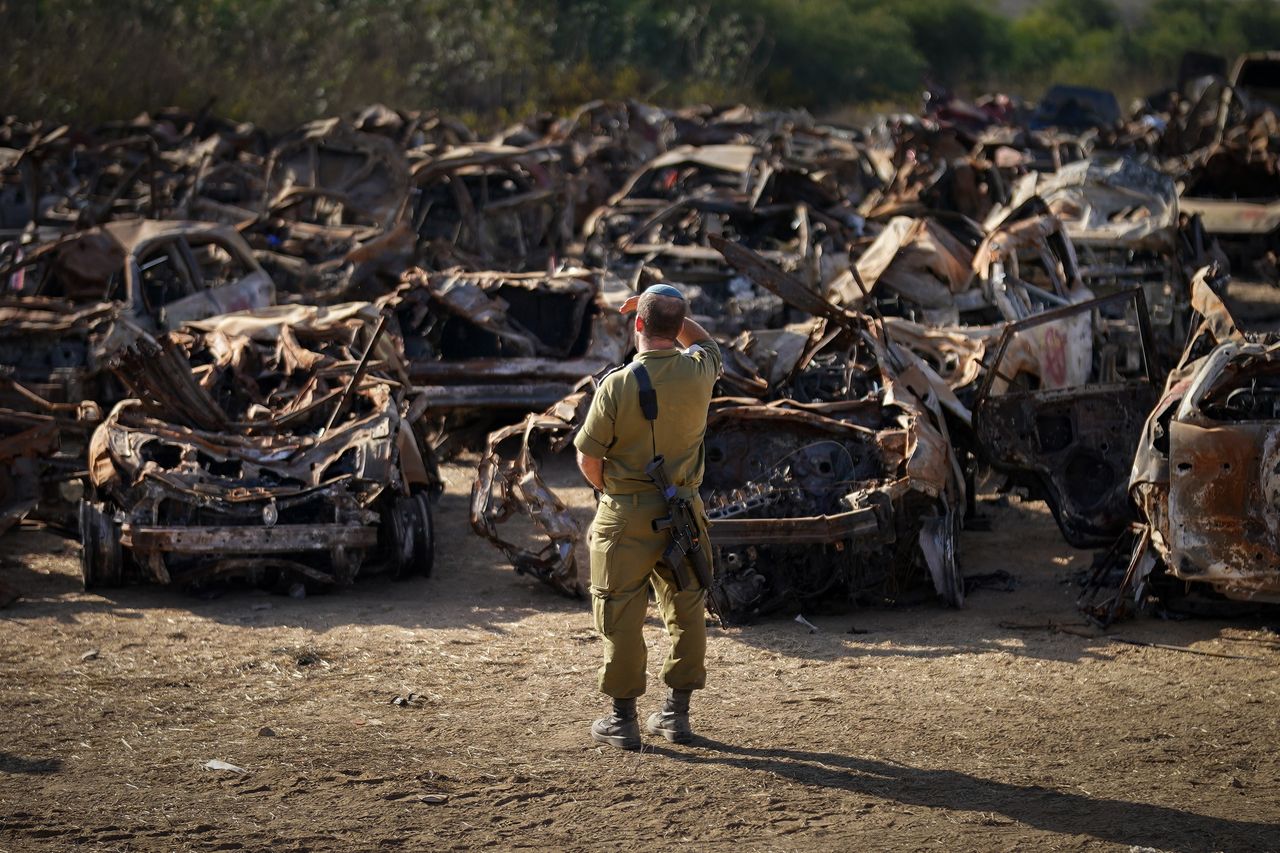 TKUMA, ISRAEL - NOVEMBER 08: An Israeli soldier pauses for thought as he views a storage site containing hundreds of destroyed cars and vehicles that have been collected to a central point after the Hamas attacks on November 08, 2023 in Tkuma, Israel. Police, forensic teams and Saka volunteers are continuing to identify the cars and any remnants of bodies. According to Jewish law all parts of a human being, including blood or body parts must be buried. A month after Hamas's Oct. 7 attacks that left 1,400 dead and over 240 held hostage, Israel has maintained a relentless bombardment of the Gaza Strip and launched a ground invasion to vanquish the militant group that governs the Palestinian territory. The Hamas-run health ministry in Gaza said that over 10,000 people have died in Gaza during the war, while the IDF has reported the deaths of several dozen Israeli soldiers. (Photo by Christopher Furlong/Getty Images)