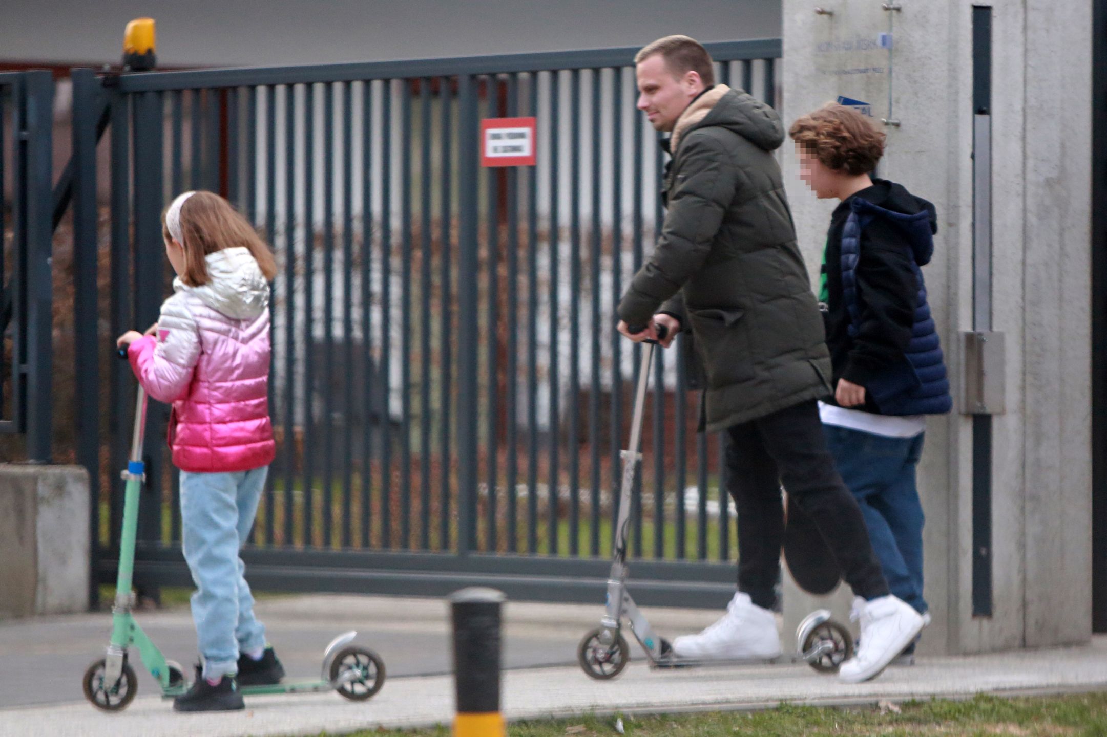 Marcin Hakiel dokazuje z dziećmi na placu zabaw