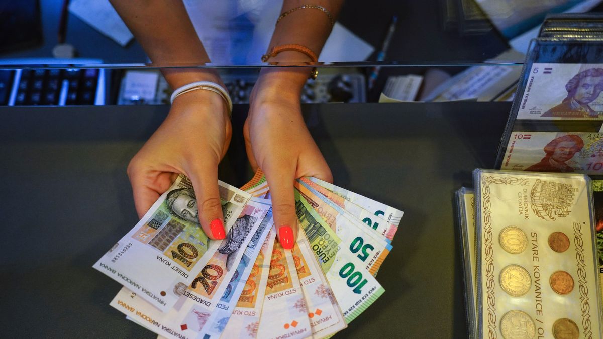 An employee shows Croatian Kuna and Euro banknotes, arranged at a currency exchange office in Dubrovnik, Croatia, on Saturday, July 23, 2022. The tourism-fueled economy of Croatia, expected to adopt the euro in January, will grow more than predicted this year before energy supply issues starting in the fourth quarter pose the risk of a 2023 recession. Photographer: Oliver Bunic/Bloomberg via Getty Images