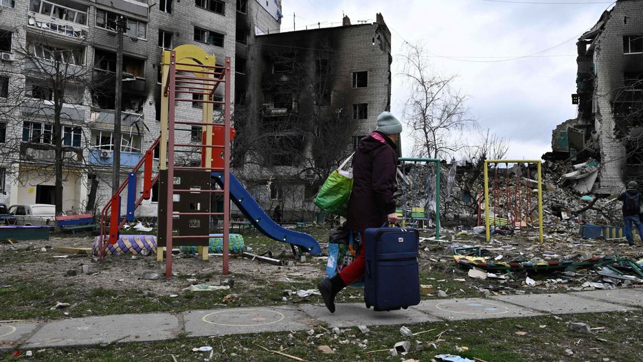 TemporaryA local woman carries belongings from a damaged house in the town of Borodianka, northwest of Kyiv, on April 6, 2022, during Russia's military invasion launched on Ukraine. - The Russian retreat last week has left clues of the battle waged to keep a grip on Borodianka, just 50 kilometres (30 miles) north-west of the Ukrainian capital Kyiv. (Photo by Genya SAVILOV / AFP)GENYA SAVILOV
