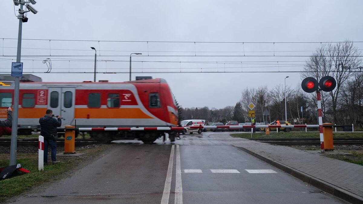 Pociąg przejeżdżający przez przejazd przy opuszczonych rogatkach i włączonym sygnalizatorze
