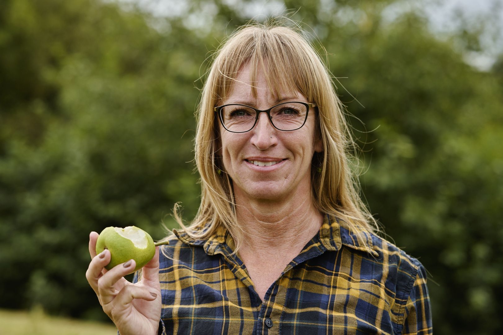 Headshot of woman having taken a bite of a fruit
Picking pears in plantation checking the taste. Close-up portrait
Westersoe