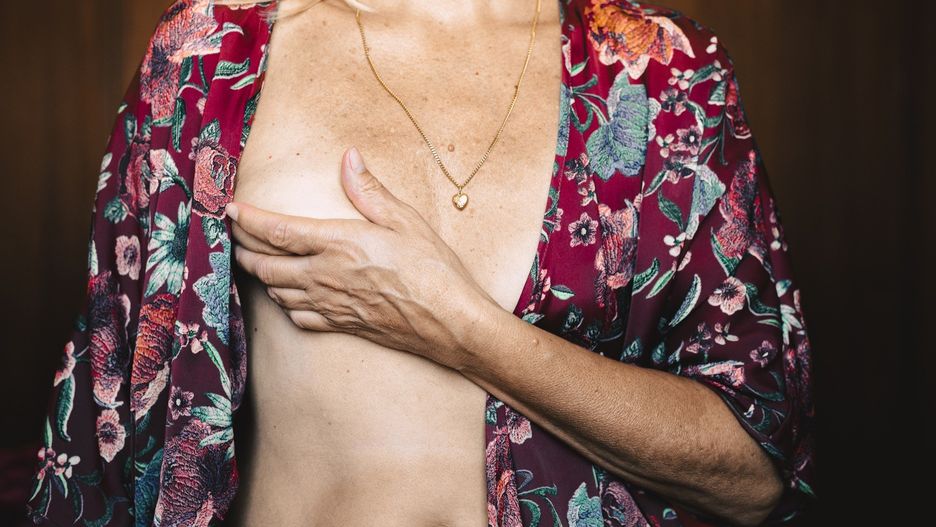 Close-up of a senior woman touching her breast