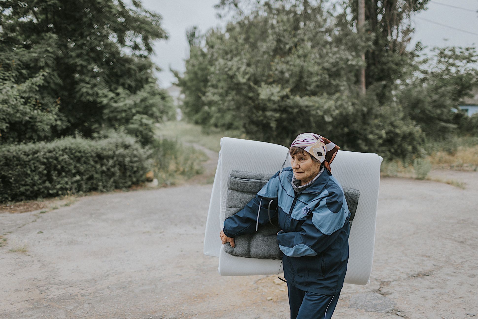 Walentyna wraca do domu z materacem, który otrzymała w ramach pomocy humanitarnej